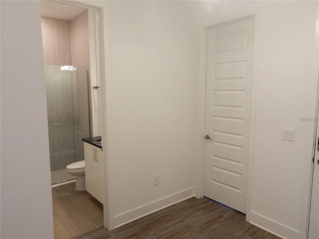 hall with dark wood-style floors and baseboards