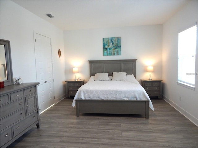 bedroom with dark wood-style flooring and baseboards
