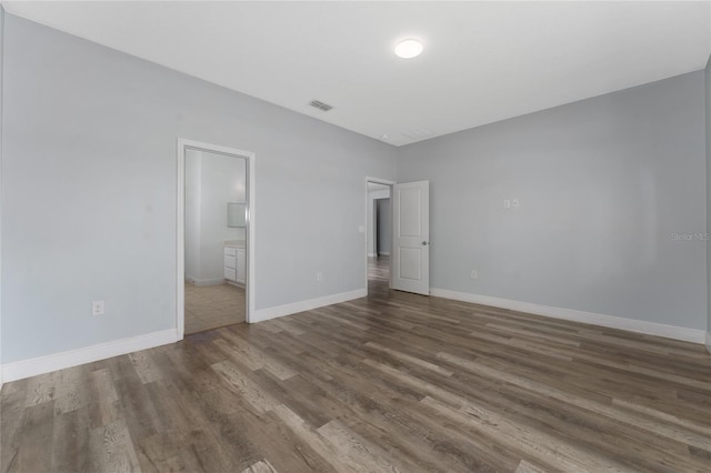 12845 Sawgrass Pine Cir, Orlando, FL 32824 - unfurnished bedroom with wood finished floors, baseboards, and ensuite bath
