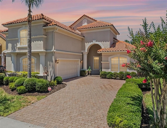 1638 Whitney Isles Dr, Windermere, FL 34786 - mediterranean / spanish-style home featuring driveway, a tiled roof, stucco siding, and a garage