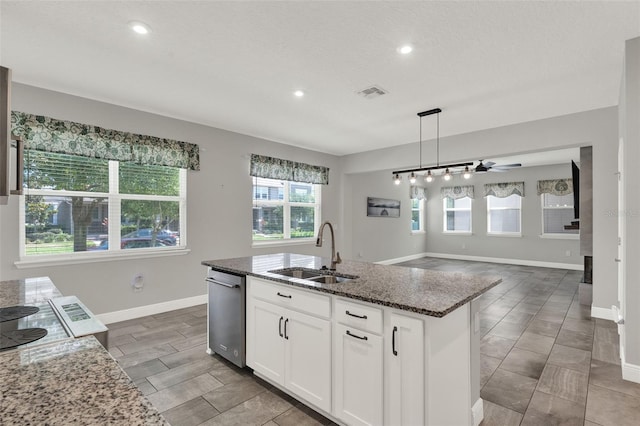 15975 Marina Bay Dr, Winter Garden, FL 34787 - kitchen featuring a sink, baseboards, dark stone countertops, ceiling fan, and a center island with sink