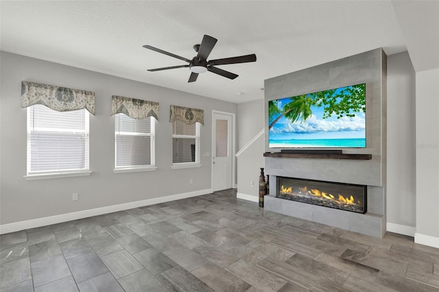 15975 Marina Bay Dr, Winter Garden, FL 34787 - unfurnished living room with a large fireplace, baseboards, and ceiling fan
