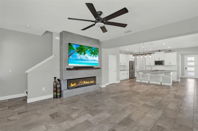 15975 Marina Bay Dr, Winter Garden, FL 34787 - unfurnished living room with baseboards, ceiling fan, a fireplace, and recessed lighting