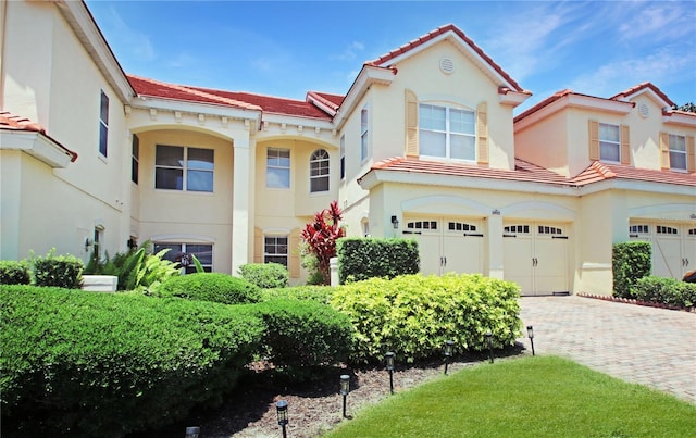 6941 Piazza St, Orlando, FL 32819 - mediterranean / spanish-style house with an attached garage, stucco siding, a tile roof, and driveway