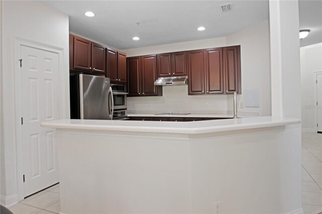 6941 Piazza St, Orlando, FL 32819 - kitchen featuring appliances with stainless steel finishes, light tile patterned flooring, under cabinet range hood, light countertops, and recessed lighting