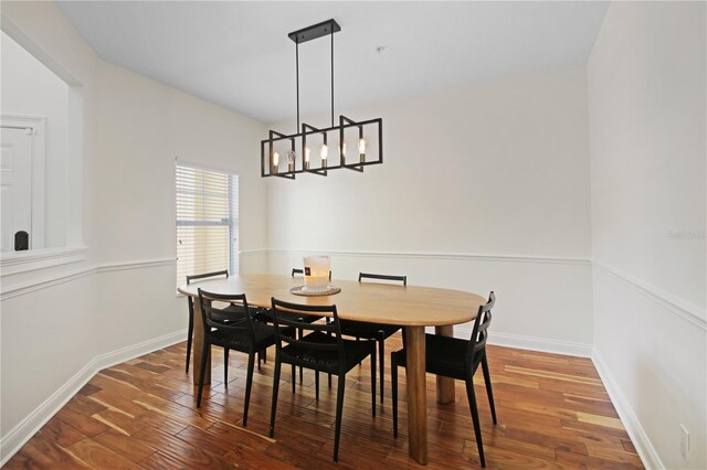 6941 Piazza St, Orlando, FL 32819 - dining room featuring a chandelier, wood finished floors, and baseboards