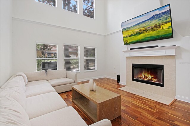 6941 Piazza St, Orlando, FL 32819 - living area with a high ceiling, wood finished floors, a tile fireplace, and baseboards