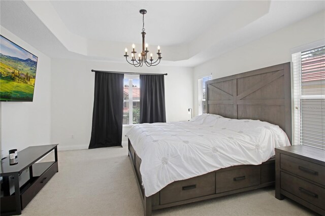 6941 Piazza St, Orlando, FL 32819 - bedroom featuring a chandelier, light colored carpet, a raised ceiling, and multiple windows