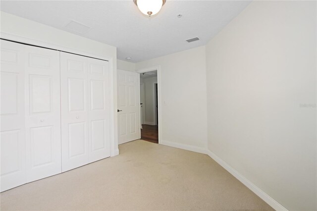 6941 Piazza St, Orlando, FL 32819 - unfurnished bedroom featuring light colored carpet, a closet, and baseboards