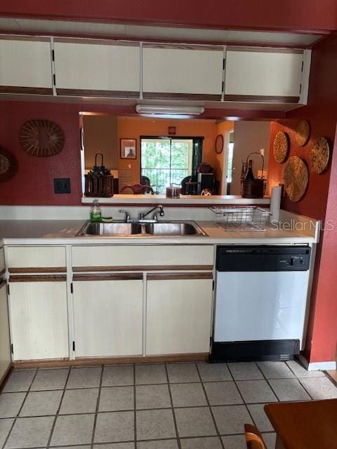 25306 Northlake Dr Unit 25306, Sanford, FL 32773 - kitchen with stainless steel dishwasher, a sink, white cabinetry, light tile patterned flooring, and light countertops