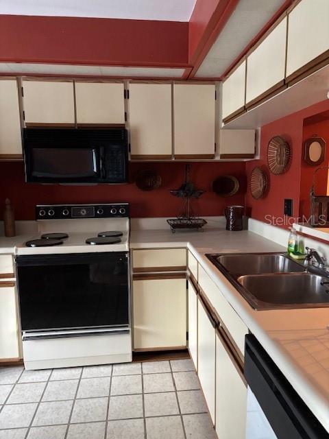 25306 Northlake Dr Unit 25306, Sanford, FL 32773 - kitchen with electric range oven, black microwave, dishwasher, a sink, and light countertops