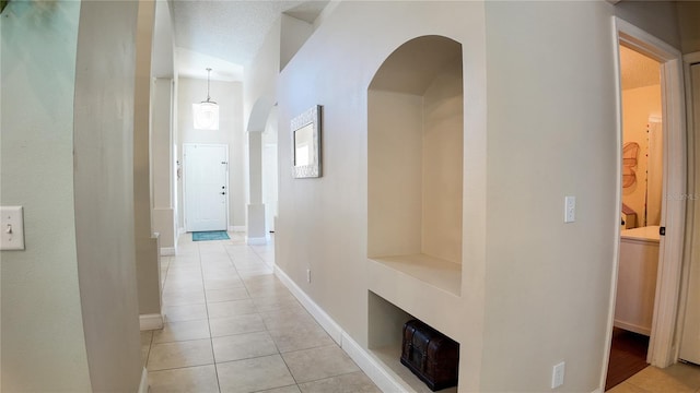 2343 Walnut Heights Rd, Apopka, FL 32703 - hall with light tile patterned flooring, arched walkways, and baseboards