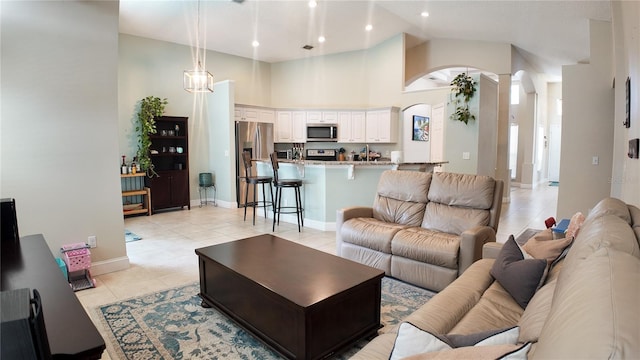 2343 Walnut Heights Rd, Apopka, FL 32703 - living area featuring arched walkways, light tile patterned floors, high vaulted ceiling, baseboards, and recessed lighting