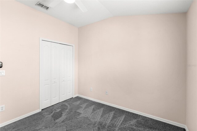 2430 Little Gem Loop, Sanford, FL 32773 - unfurnished bedroom with dark carpet, lofted ceiling, a closet, baseboards, and ceiling fan