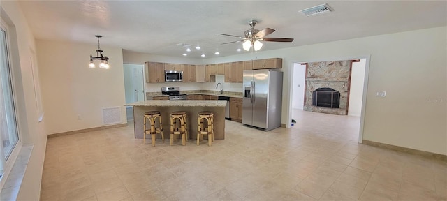122 N Cedarview Ter, Inverness, FL 34453 - kitchen featuring stainless steel appliances, a sink, a ceiling fan, a center island, and light countertops