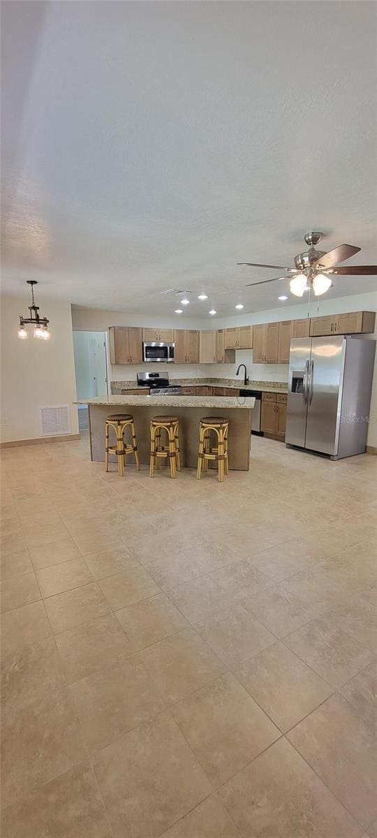 122 N Cedarview Ter, Inverness, FL 34453 - kitchen featuring appliances with stainless steel finishes, a breakfast bar, a ceiling fan, recessed lighting, and a center island