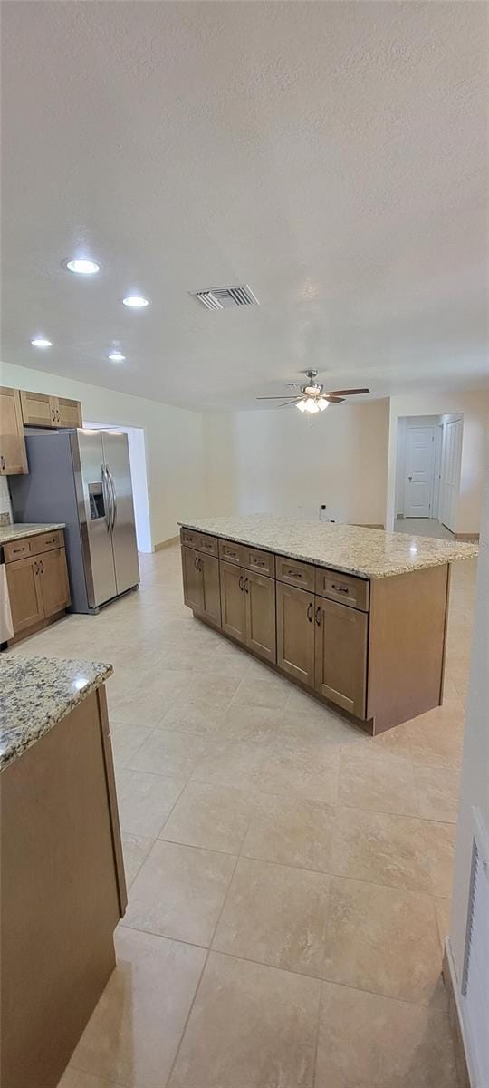122 N Cedarview Ter, Inverness, FL 34453 - kitchen featuring stainless steel refrigerator with ice dispenser, a ceiling fan, light stone countertops, recessed lighting, and a kitchen island