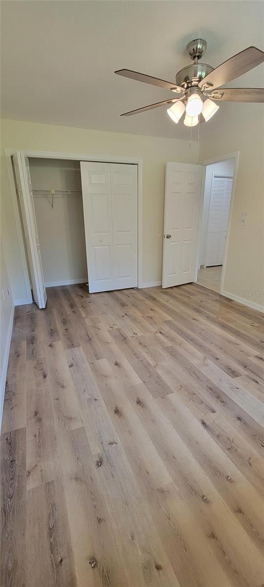 122 N Cedarview Ter, Inverness, FL 34453 - unfurnished bedroom with light wood-style floors, a closet, baseboards, and a ceiling fan