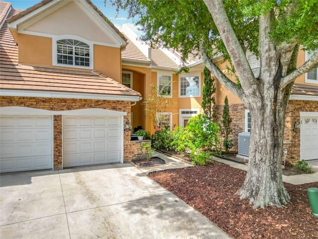 7323 Cypress Grove Rd Unit 87, Orlando, FL 32819 - multi unit property featuring stucco siding, driveway, a tile roof, stone siding, and an attached garage