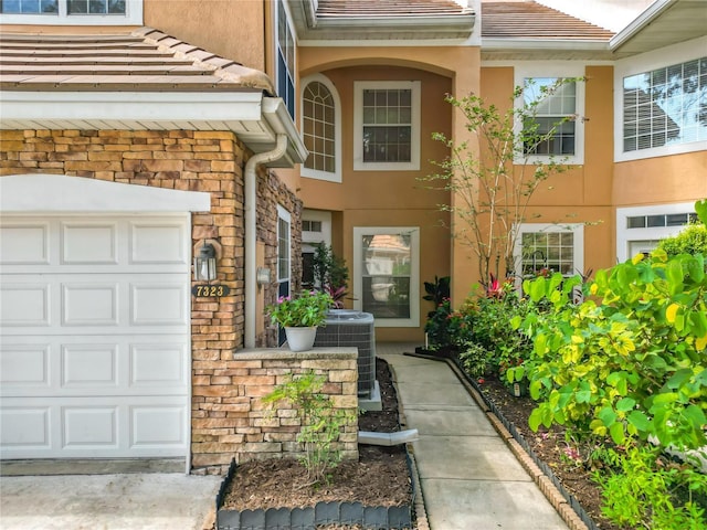 7323 Cypress Grove Rd Unit 87, Orlando, FL 32819 - view of exterior entry featuring stucco siding and cooling unit