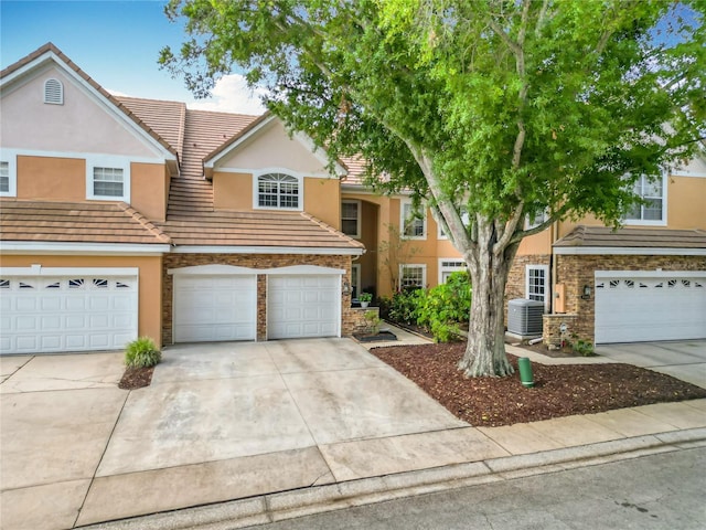 7323 Cypress Grove Rd Unit 87, Orlando, FL 32819 - view of property featuring stone siding, central AC unit, stucco siding, and driveway