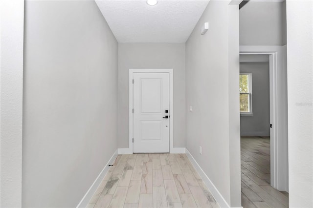 6805 SW 131st Cir, Ocala, FL 34481 - doorway featuring light wood-style floors, baseboards, and a textured ceiling