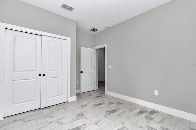 6805 SW 131st Cir, Ocala, FL 34481 - unfurnished bedroom with a closet, baseboards, light wood finished floors, and a textured ceiling