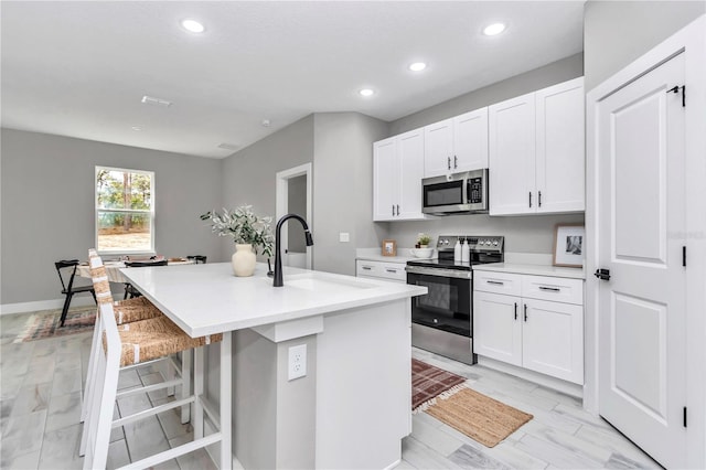 6805 SW 131st Cir, Ocala, FL 34481 - kitchen featuring stainless steel appliances, a sink, a kitchen island with sink, recessed lighting, and white cabinetry