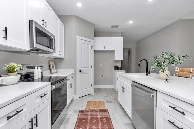 6805 SW 131st Cir, Ocala, FL 34481 - kitchen with stainless steel appliances, a sink, white cabinetry, and recessed lighting