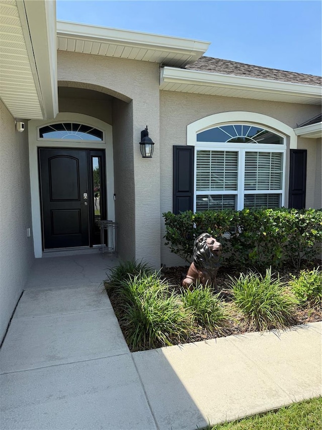 6800 SE 12th Pl, Ocala, FL 34472 - doorway to property featuring stucco siding and roof with shingles
