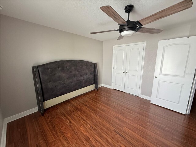 6800 SE 12th Pl, Ocala, FL 34472 - unfurnished bedroom with baseboards, wood finished floors, a ceiling fan, a closet, and a textured ceiling