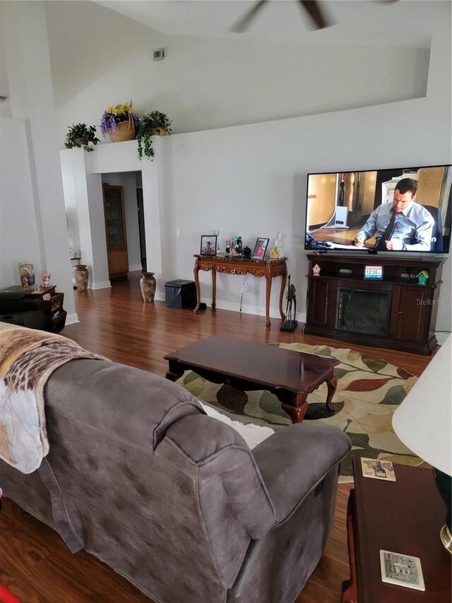 6800 SE 12th Pl, Ocala, FL 34472 - living area with high vaulted ceiling, a glass covered fireplace, wood finished floors, baseboards, and a ceiling fan
