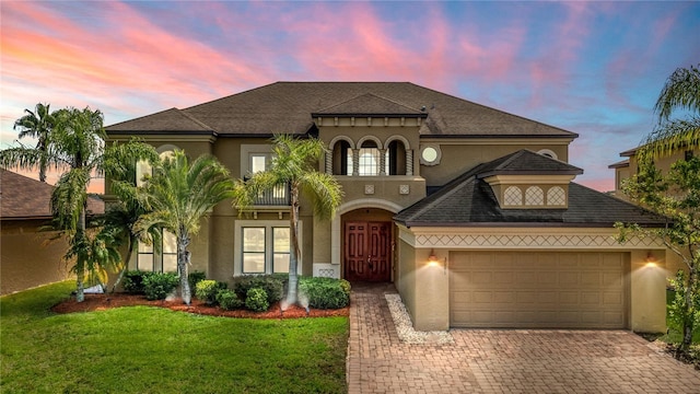3041 Boating Blvd, Kissimmee, FL 34746 - view of front facade featuring stucco siding, decorative driveway, a lawn, and an attached garage