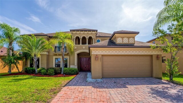 3041 Boating Blvd, Kissimmee, FL 34746 - mediterranean / spanish home with decorative driveway, an attached garage, a front yard, and stucco siding
