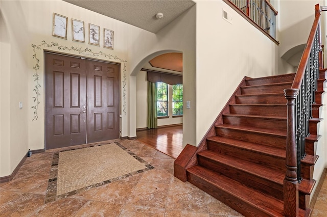 3041 Boating Blvd, Kissimmee, FL 34746 - entryway featuring arched walkways, baseboards, inlaid floor details, and stairway