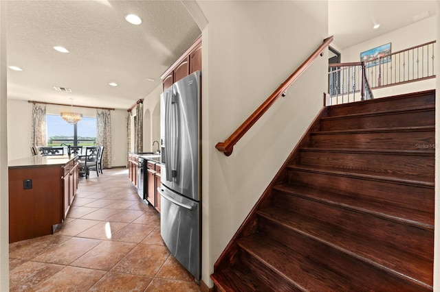 3041 Boating Blvd, Kissimmee, FL 34746 - staircase featuring a textured ceiling, recessed lighting, tile patterned floors, and a chandelier