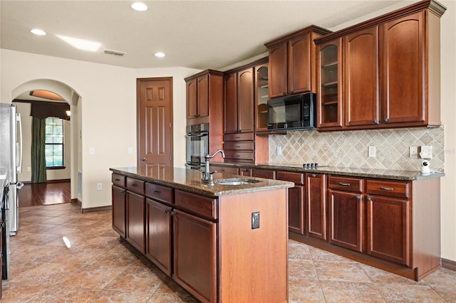 3041 Boating Blvd, Kissimmee, FL 34746 - kitchen featuring a sink, black appliances, arched walkways, dark stone counters, and decorative backsplash