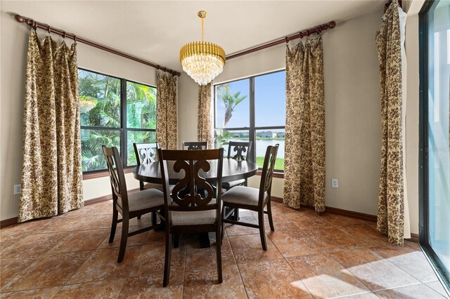 3041 Boating Blvd, Kissimmee, FL 34746 - dining area featuring a chandelier, baseboards, a water view, and stone finish floors