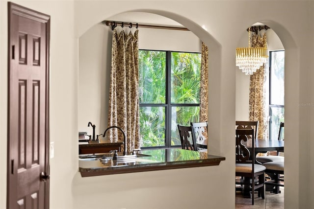 3041 Boating Blvd, Kissimmee, FL 34746 - interior space featuring a chandelier, arched walkways, dark countertops, and a sink