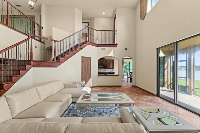 3041 Boating Blvd, Kissimmee, FL 34746 - living area featuring stairs, arched walkways, a high ceiling, tile patterned flooring, and baseboards