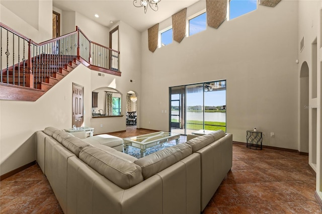 3041 Boating Blvd, Kissimmee, FL 34746 - living area featuring a towering ceiling, arched walkways, baseboards, a water view, and stone finish flooring