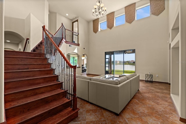 3041 Boating Blvd, Kissimmee, FL 34746 - living room featuring a chandelier, plenty of natural light, stairs, a high ceiling, and baseboards
