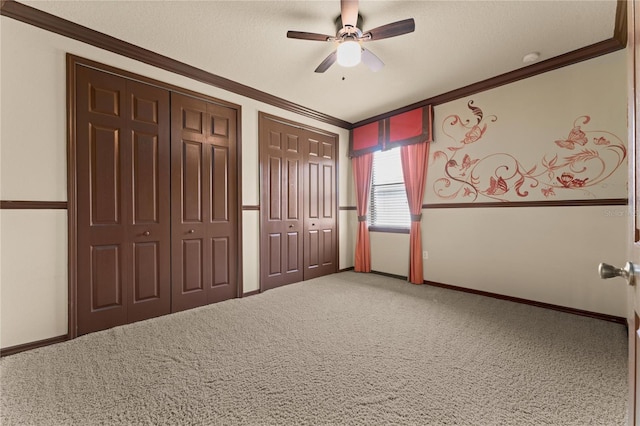 3041 Boating Blvd, Kissimmee, FL 34746 - unfurnished bedroom with multiple closets, ornamental molding, carpet, a textured ceiling, and ceiling fan