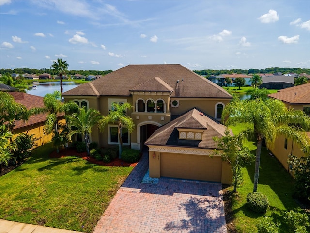 3041 Boating Blvd, Kissimmee, FL 34746 - mediterranean / spanish house with stucco siding, a water view, decorative driveway, and a garage