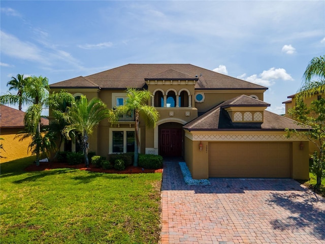 3041 Boating Blvd, Kissimmee, FL 34746 - mediterranean / spanish-style house with stucco siding, an attached garage, decorative driveway, and a front lawn