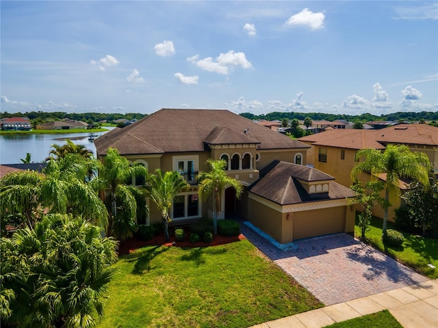 3041 Boating Blvd, Kissimmee, FL 34746 - mediterranean / spanish house with decorative driveway, a front lawn, stucco siding, and a water view