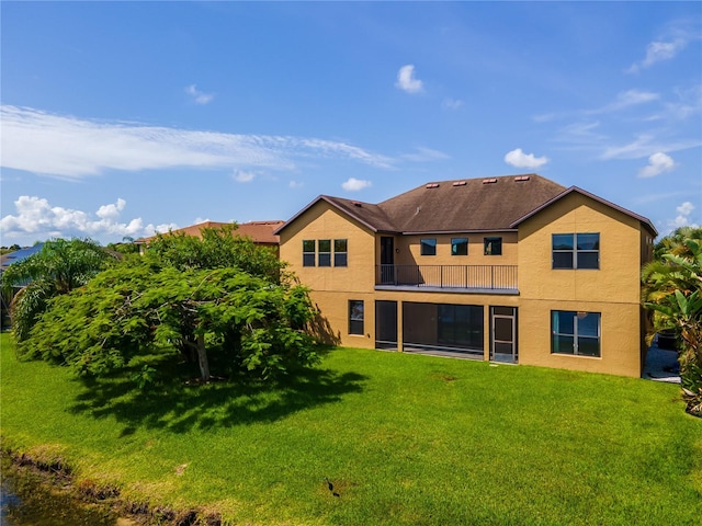 3041 Boating Blvd, Kissimmee, FL 34746 - rear view of property featuring a balcony, stucco siding, and a yard