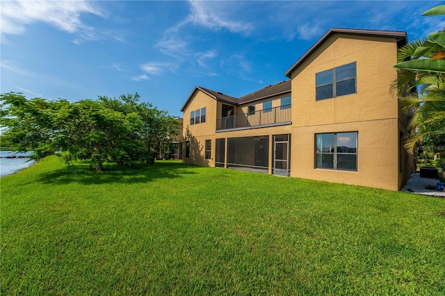 3041 Boating Blvd, Kissimmee, FL 34746 - back of property featuring a balcony, stucco siding, and a lawn
