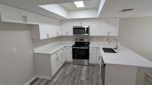 609 Whittingham Pl, Lake Mary, FL 32746 - kitchen with appliances with stainless steel finishes, a sink, a peninsula, and light wood-style flooring