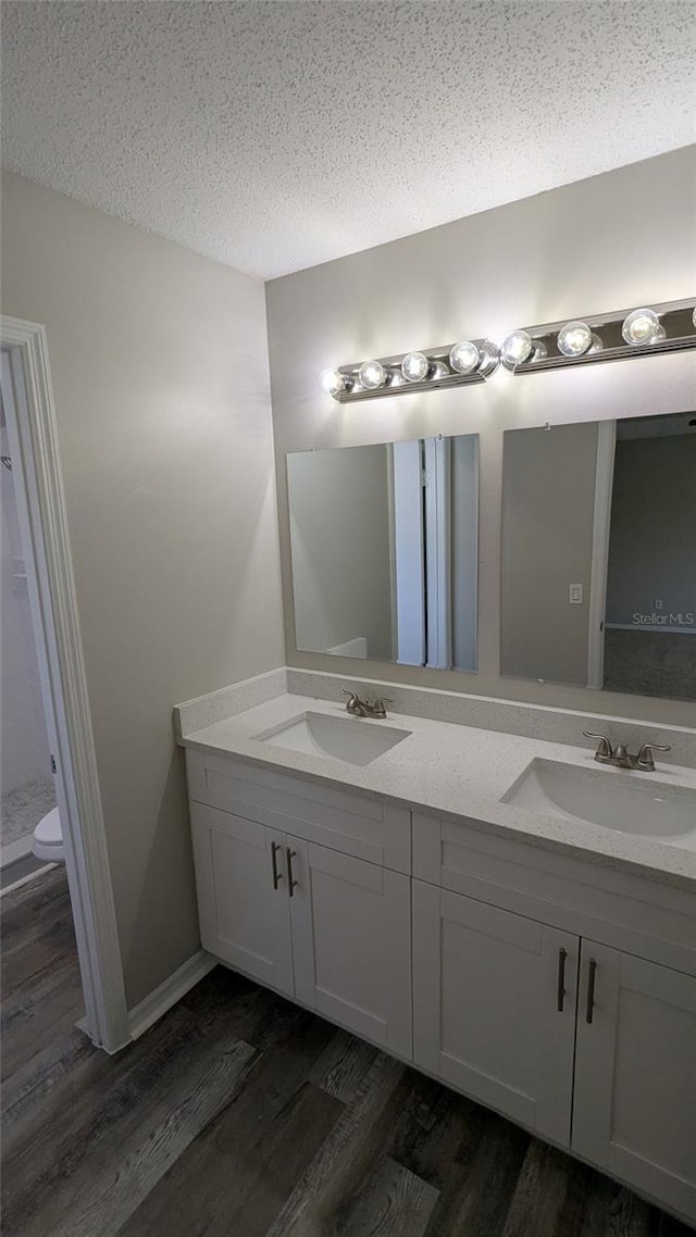 609 Whittingham Pl, Lake Mary, FL 32746 - full bath featuring wood finished floors, double vanity, a textured ceiling, and toilet